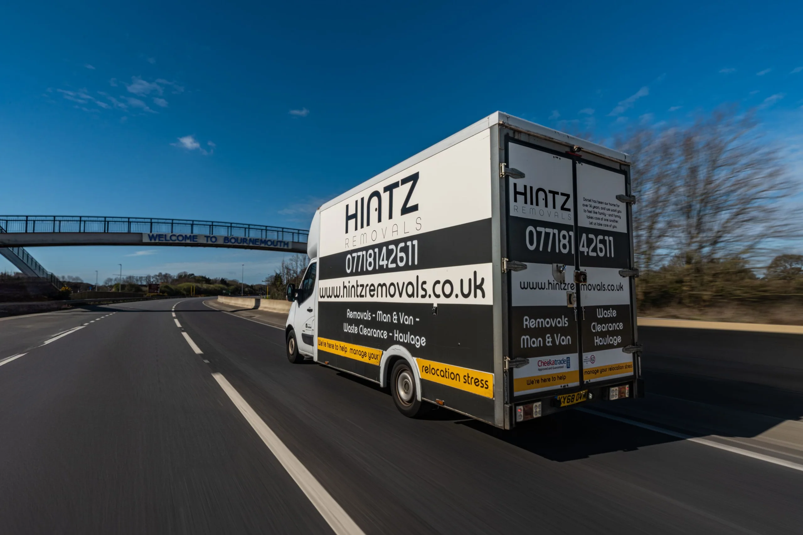 Hintz Removals van driving beneath the Welcome to Bournemouth footbridge